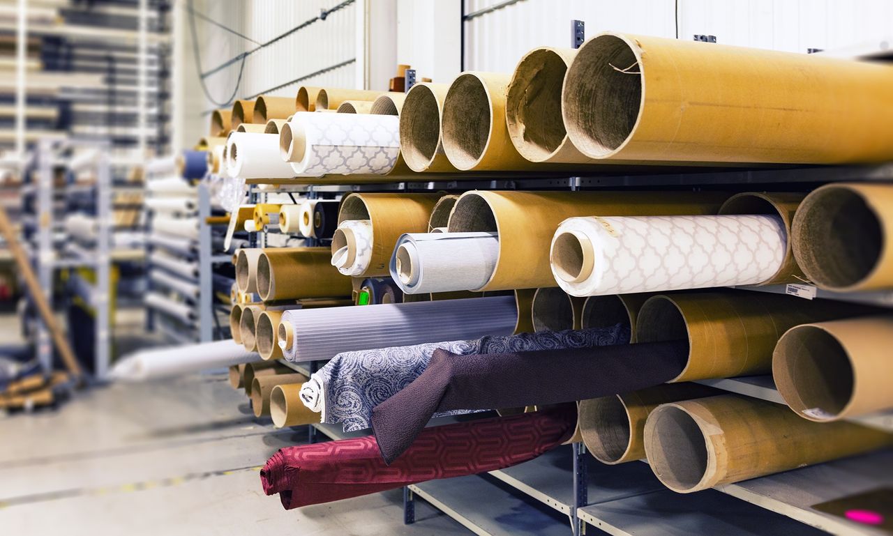 about-us-img Rows of textile rolls stored in a factory for industrial manufacturing.
