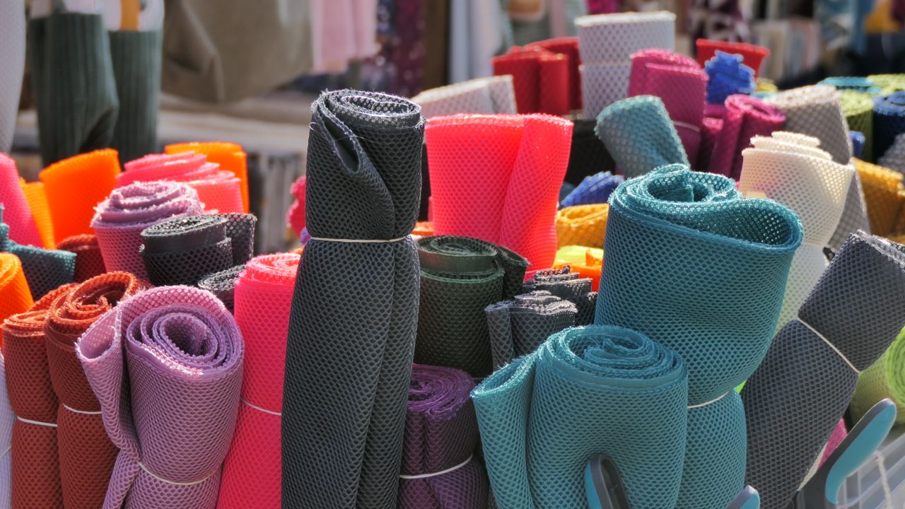 our-services-03 Vibrant rolls of mesh fabric displayed at a market in Mayen, Germany.