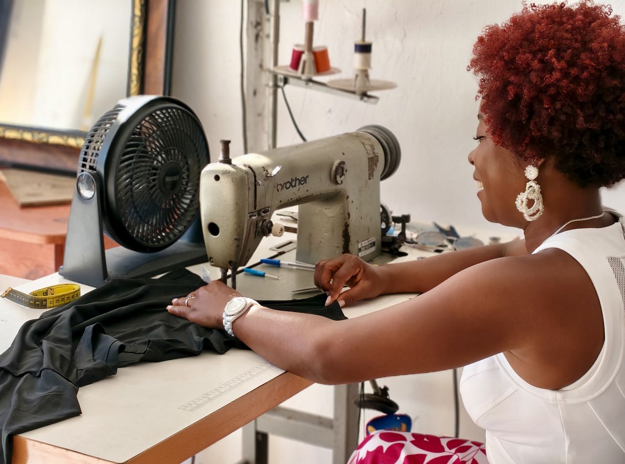 A skilled seamstress operating a sewing machine in a stylish studio, creating a garment.