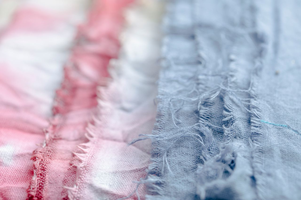Crafting Captivating Headlines: Your awesome post title goes here Blue and pink textile with threads placed on surface in modern professional studio on blurred background during production of clothes